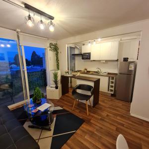 eine Küche und ein Wohnzimmer mit einer Couch und einem Tisch in der Unterkunft Departamento 3 dormitorios en villarica in Villarrica