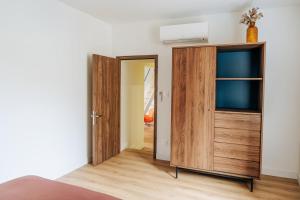 a bedroom with a wooden cabinet and a door at Appartement centre village Tavel in Tavel +5 photos