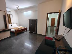 a living room with a bed and a television at SHREVIK Comforts in Chikmagalūr