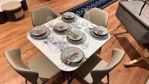 a white table with plates and glasses on it at Suite Bahiya 15 in Fez