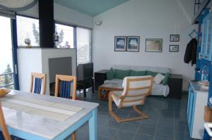 a living room with a couch and a table and chairs at Cottage in Tiros