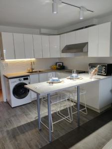 a kitchen with a table and a washing machine at Modern Studio in Pelican with pool-walk to Beach, Dining, Entertainment in Simpson Bay
