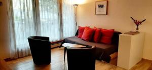 a living room with a couch and red pillows at Rothorn Center A 1Og Schöpfer in Sörenberg