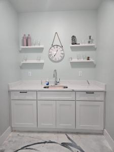 a kitchen with a sink and a clock on the wall at The Backwoods Paradise in Logan