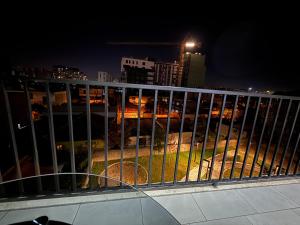een balkon met uitzicht op de stad 's nachts bij Modern 2BR Near City Ring & Main Road Access in Tirana