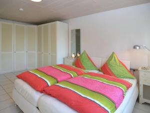 a large bed with colorful blankets and pillows on it at Ferienwohnung Relax In Homberg Ot Welferode in Welferode +6 photos