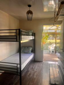 a bedroom with two bunk beds and a window at Hiariki Lodge in Hiva Oa