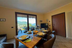 ein Esszimmer mit einem Tisch mit Stühlen und einem großen Fenster in der Unterkunft Clubhouse in Menaggio