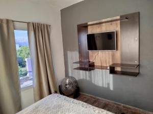 een slaapkamer met een tv en een bed en een raam bij Flor silvestre in Carpintería