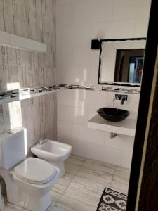 een badkamer met een toilet, een wastafel en een spiegel bij Flor silvestre in Carpintería