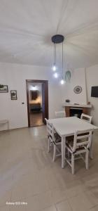 ein Wohnzimmer mit einem weißen Tisch und Stühlen in der Unterkunft Casa Marigé in San Nicola Arcella