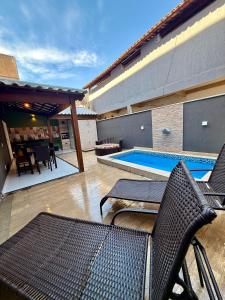 un patio avec des chaises et une piscine dans l'établissement Grazi Arraial Beach - Centro Arraial do Cabo, à Arraial do Cabo
