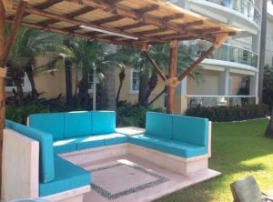 eine Pergola mit blauen Bänken in einem Garten in der Unterkunft Diamante Lakes in Acapulco