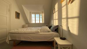 a small bedroom with a bed with a window at Thurø Kro B&B in Svendborg