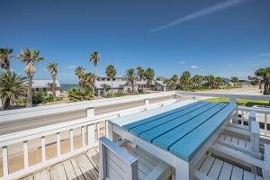 罗克波特Poppy's Paradise - The Best Vacation Rental in Rockport!的建筑物屋顶上的野餐桌，周围环绕着棕榈树