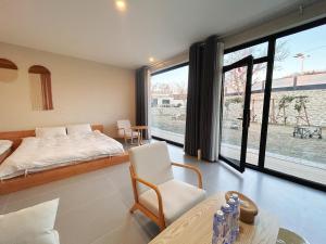 ein Schlafzimmer mit einem Bett und einem großen Fenster in der Unterkunft Sanmo Nanshan Boutique Homestay in Henanzhai