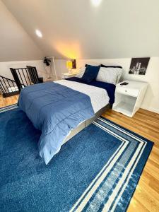 北卑尔根NYC Holiday Stay in Stylish Loft 6 Miles from Times Square的卧室里有一张大床和一块蓝色地毯 更多3张照片