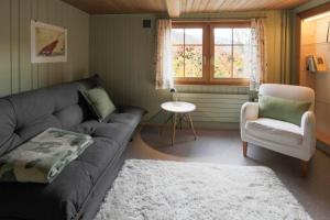 KrummenauにあるHaus Zum Rehのリビングルーム(ソファ、椅子、窓付)