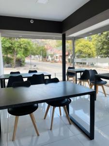 ein Raum mit Tischen und Stühlen und einem großen Fenster in der Unterkunft Astoria in Villa Carlos Paz