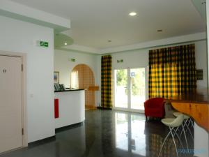 a living room with a table and a red chair at Panorama apartments in Agios Gordios