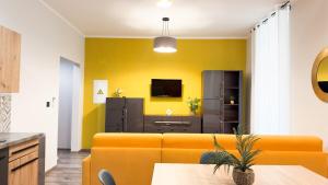 sala de estar amarilla con sofá y TV en Spacious and bright house in the center - parking, en Verona