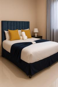 a bedroom with a large bed with yellow pillows at Bear Haven Lodge in Manguzi