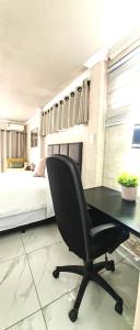 a bedroom with a desk and a bed and a chair at Stay-Tiah Pastel, Durban in Durban
