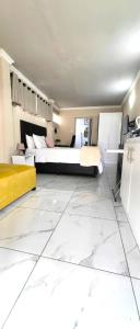 a large room with a bed and a kitchen at Stay-Tiah Pastel, Durban in Durban