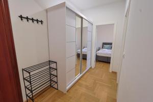 a room with a closet and a bedroom with a bed at Kosta Boutique Apartment in Banja Luka