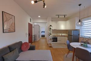 a living room and kitchen with a couch and a table at Kosta Boutique Apartment in Banja Luka