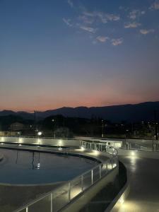 einen Pool in der Nacht mit Bergblick in der Unterkunft Apartamento Bertioga Torres in Bertioga