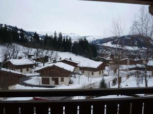 a view from a window of a snow covered village at Le Hameau des Neiges in Demi-Quartier