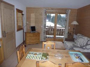 una sala de estar con una mesa y un sofá en Le Hameau des Neiges, en Demi-Quartier