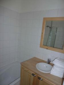 een badkamer met een wastafel en een bad bij Le Hameau des Neiges in Demi-Quartier
