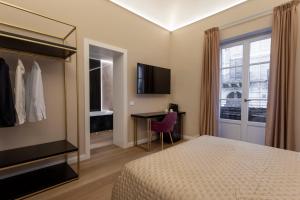 a bedroom with a bed and a desk and a window at Isidoro Luxury Suites in Palermo