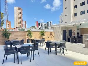 eine Gruppe von Tischen und Stühlen auf einer Dachterrasse in der Unterkunft JSmart Dom in Fortaleza