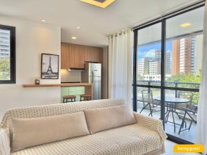 ein Wohnzimmer mit Sofa und eine Küche in der Unterkunft JSmart Dom in Fortaleza