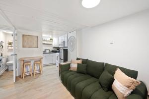 un salon avec un canapé vert et une cuisine dans l'établissement Juanita Bay Cottages B2, à Kirkland