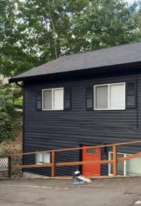 une maison noire avec une porte rouge dans l'établissement Juanita Bay Cottages B2, à Kirkland