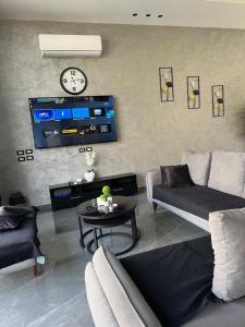 un salon avec un canapé et une horloge au mur dans l'établissement Villa Ohaio, à Amman