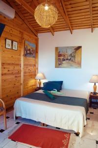 a bedroom with a large bed in a room with wooden walls at L'artisan in Hergla +52 photos