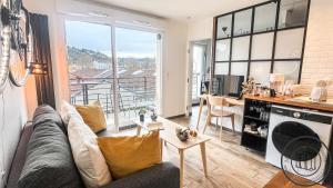 ein Wohnzimmer mit Sofa und Tisch in der Unterkunft Au Petit Vélo - Parking & Balcon Vienne in Vienne