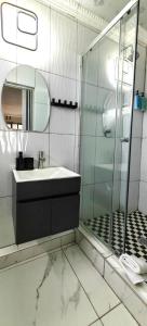a bathroom with a sink and a glass shower at Stay-Tiah Pastel, Durban in Durban +5 photos