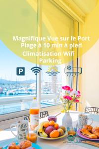 a table topped with plates of food and a window at Les Terrasses du Port - VUE Port - Wifi - Parking - Clim in Leucate-Plage