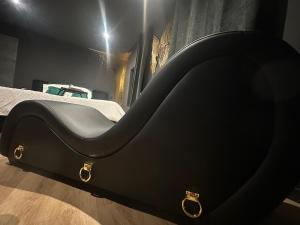 a black bed with gold handles in a bedroom at Le Secret' - Balnéo - Romantique Room in Pélussin
