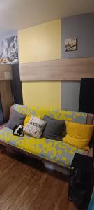 een gele bank met een hond erop in een kamer bij Chambre Privée Familiale 13m2 in Le Kremlin-Bicêtre