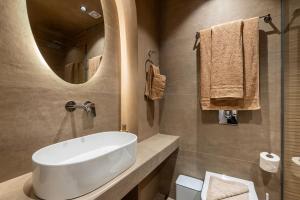 a bathroom with a white sink and a mirror at Socrates Studios and Suites in Tigaki +48 photos