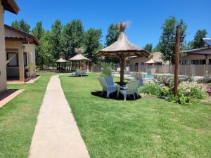 a patio with chairs and a table and a umbrella at Cabaña premium! in Villa Anizacate