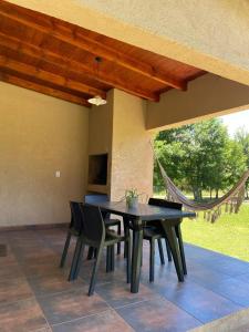 a patio with a table and chairs and a hammock at Cabaña premium! in Villa Anizacate