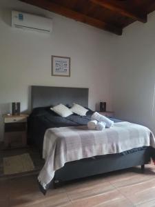 a bedroom with a large bed with a white wall at Cabaña premium! in Villa Anizacate +20 photos